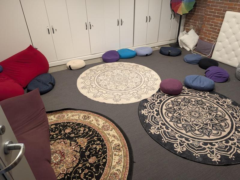 Three colorful round mats with bean bag chairs scattered across the floor.
