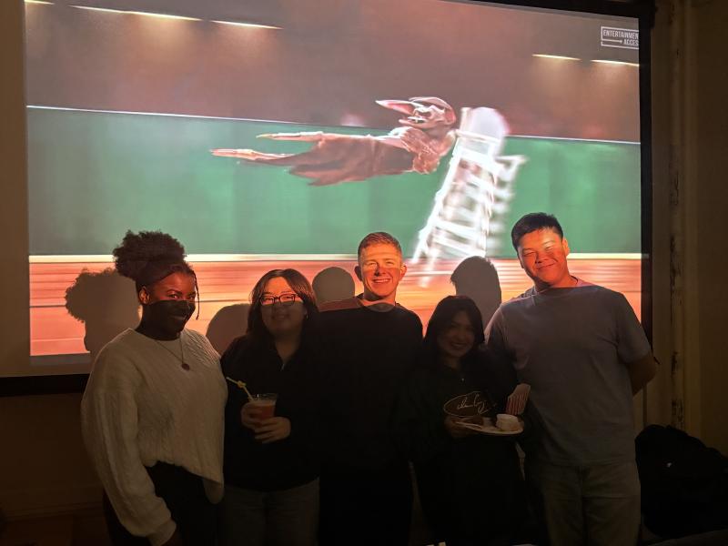 5 people standing in front of a projector screen.