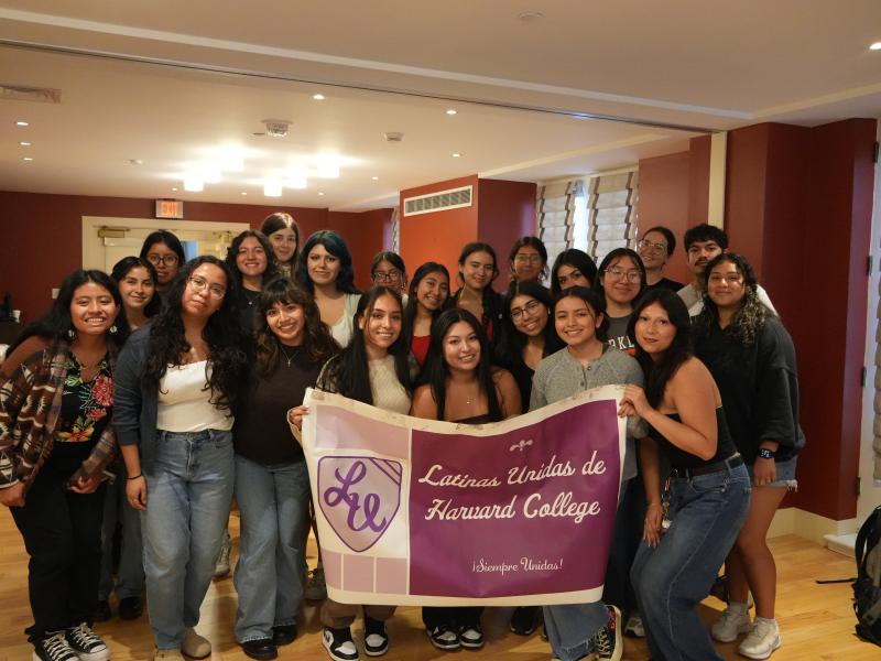 A group of students holding a Latinas Unidas de Harvard College banner. 