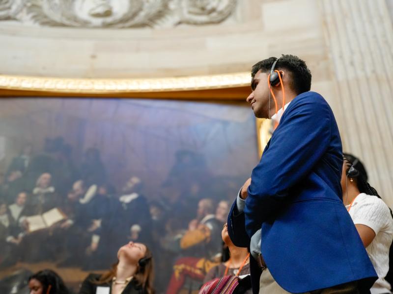 A student listens to a headset during a tour of the Capitol Building.