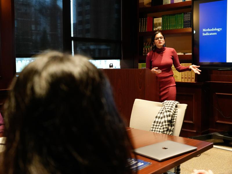A woman speaking to students in front of the room during a presentation.