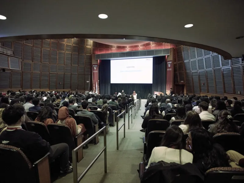 Large auditorium at the Arab Conference at Harvard 2025 with speakers and an audience.