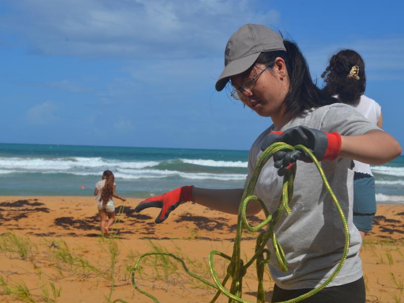 Athena Siow ‘29 prepares a rope to measure a transect of beach.