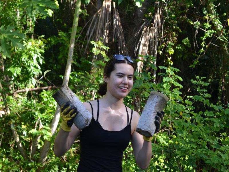 Lauren Huber ‘29 carrying tree seedlings across the nursery.