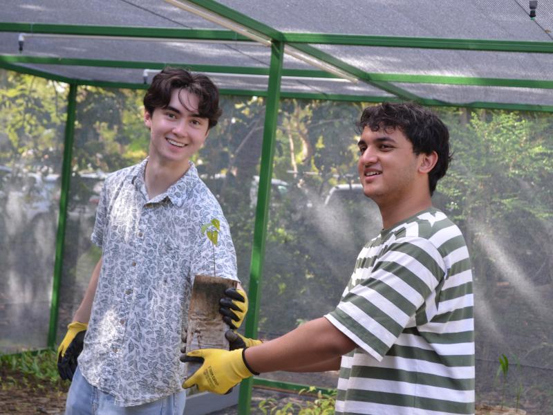 Ezra Rottman ‘29 and Bishwo Jeet ‘29 holding a tree sapling.