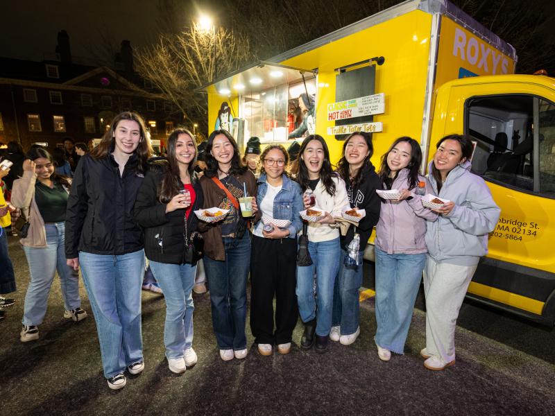 Students smiling next to a food truck.