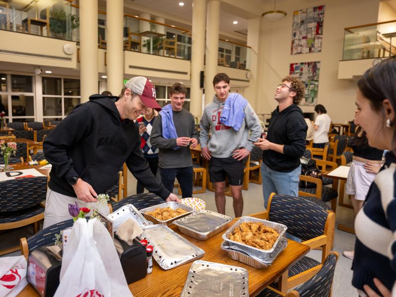 Dean Deming unwrapping a container of chicken tenders for students.