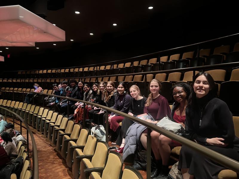 Students sitting in a row of empty theatre seats at Jazz at Lincoln Center Orchestra.