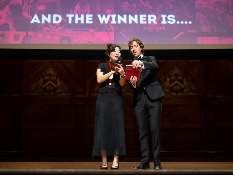 Hosts Joy Ho and Bernardo de Moura Sequeira reading the results from an envelope onstage.