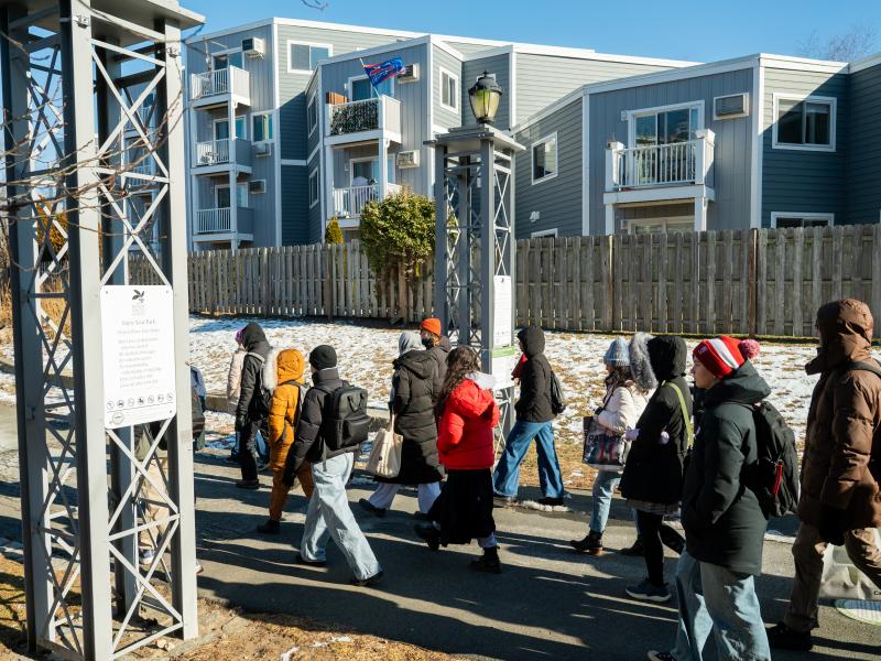 The group walking in a line through a neighborhood walkway in East Boston.