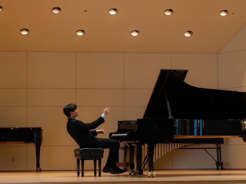 Christopher Shin ‘27 onstage at Paine Hall playing piano.