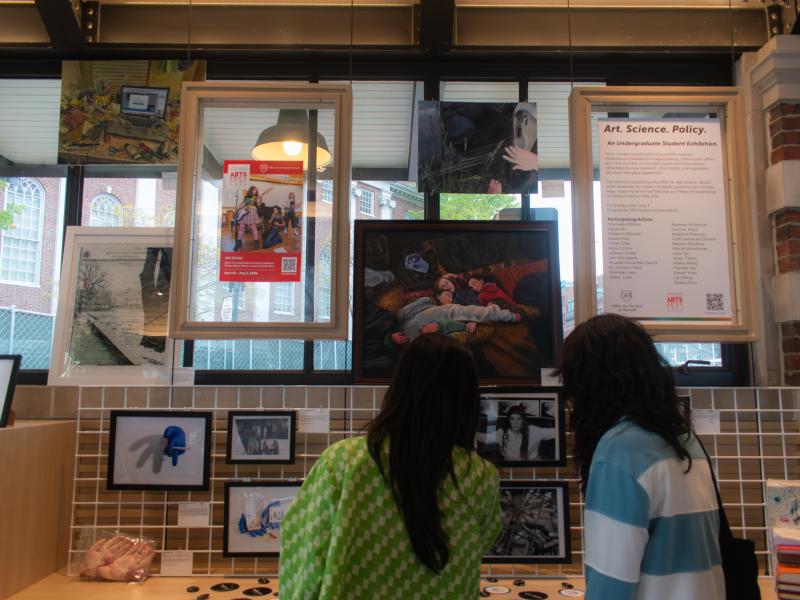 The Art, Science, and Policy Kiosk with students looking at it.