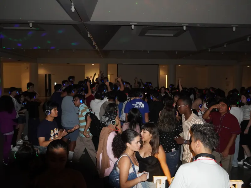 students at a silent disco, with lit up headphones