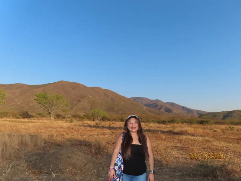 Person in front of mountain range. 