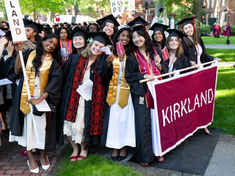A group of female members of Kirkland House hold signs and banners for Kirkland to lead the group.