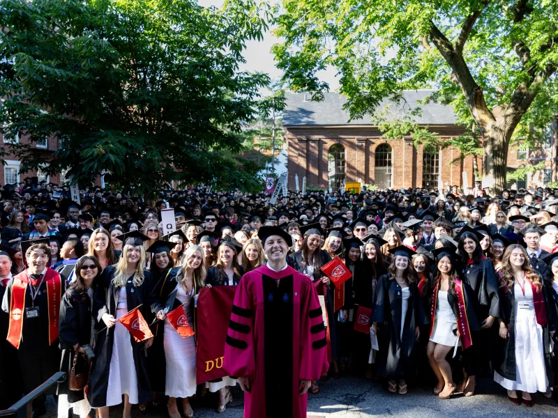 Dean David Deming standing in front of the Class of 2026 smiling at Valediction.