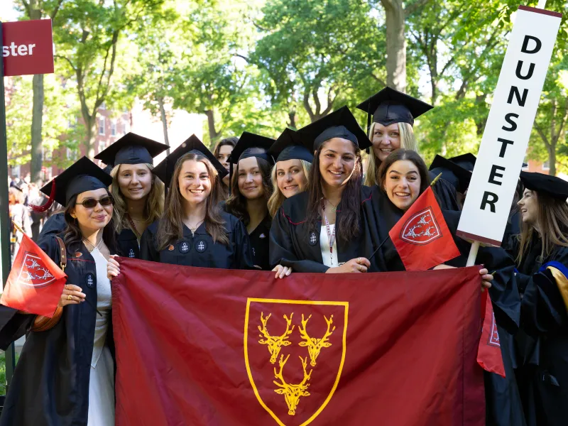 Female members of Dunster House held up a sign and banner for Dunster to lead the House.