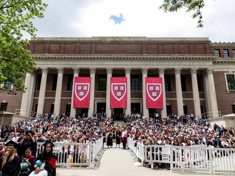 Wide shot of crowds of people in front of Widener Library. 