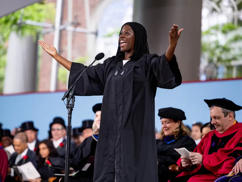 Kiesse Nanor '26 standing onstage speaking with her arms outstretched.