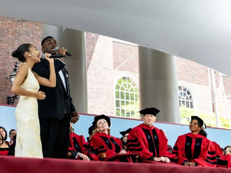 Samuel Hines '29 and Gabrielle Greene '27 singing together onstage during the ceremony.