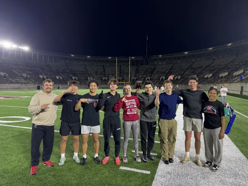 A diverse group of student athletes pose for a photo holding up the asl sign for "K" to celebrate Kirkland's victory.