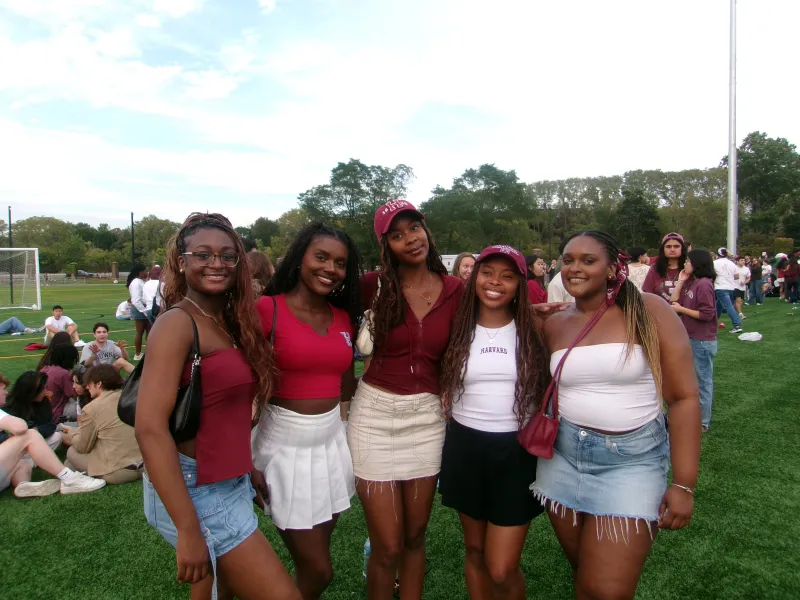 A picture of myself and my friends at the Harvard vs. Brown football game. Each person is wearing a variation of Harvard merchandise and crimson