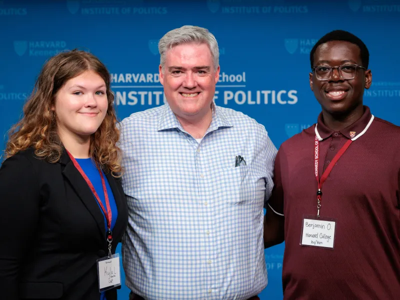 Dean of Students Tom Dunne (center) smiling with a female student (left) and male student (right).