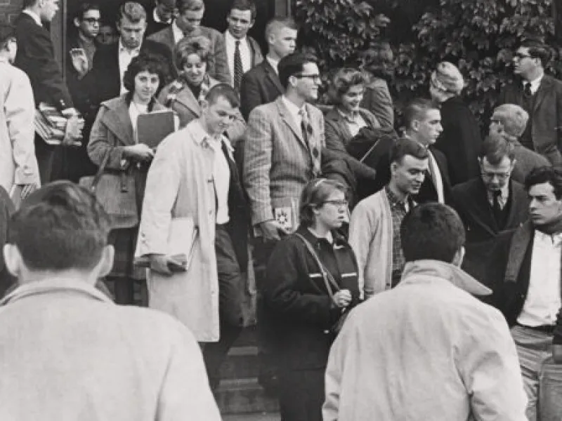 A black and white image of students in the 1960s filing out of Emerson Hall.