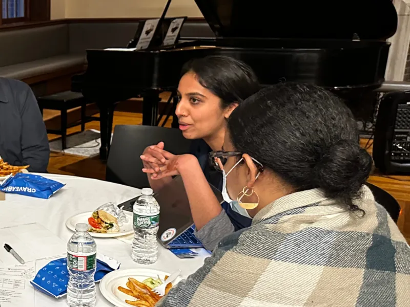 A group of people sitting around a table and talking.