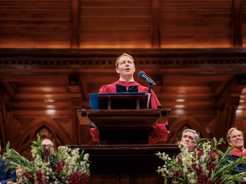 Dean David Deming speaking at the podium during Convocation.