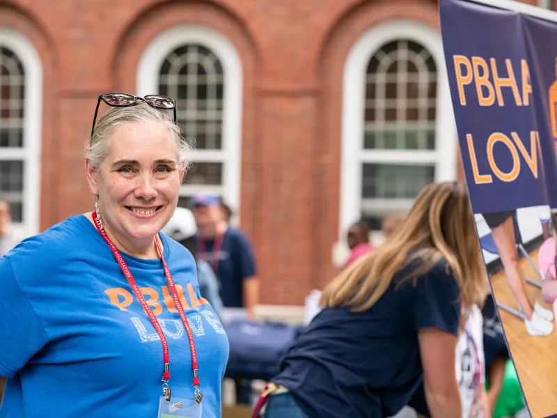 A woman smiling at the PBHA table.