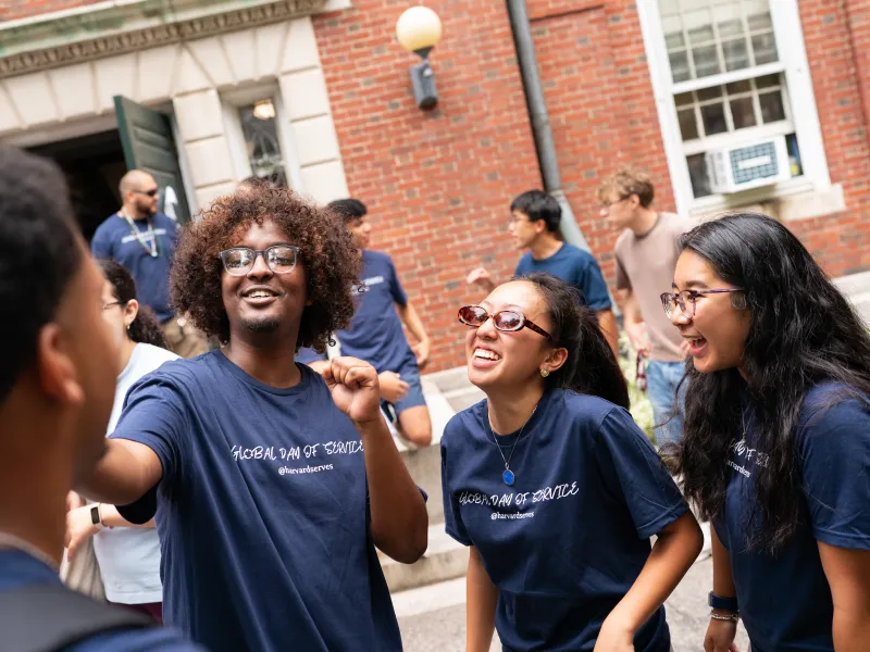 A group of three students laughing together while recording a video.
