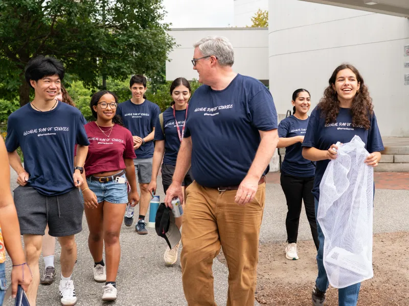 Dean of Students Tom Dunne walking and smiling with student volunteers.