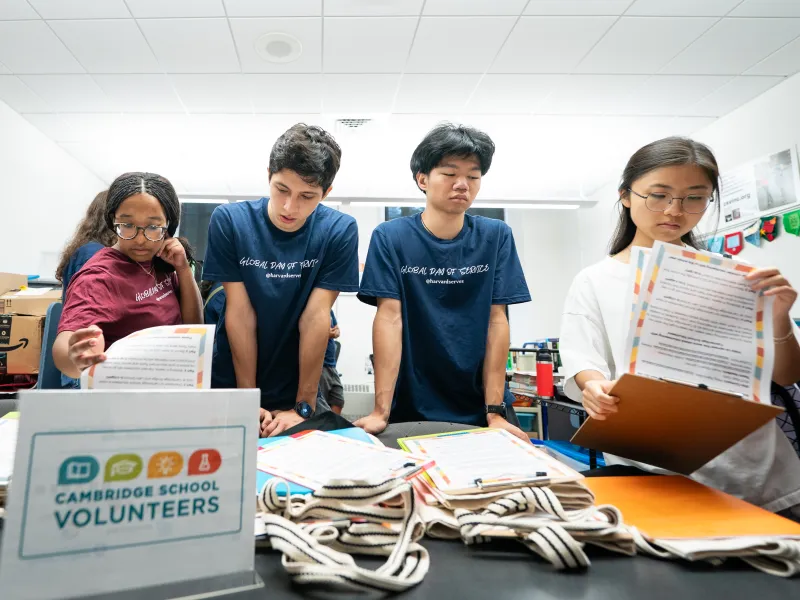 Four students arranging school supplies.