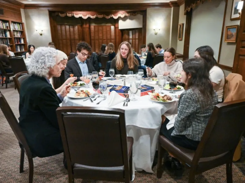 People sitting around a table and having a meal together.