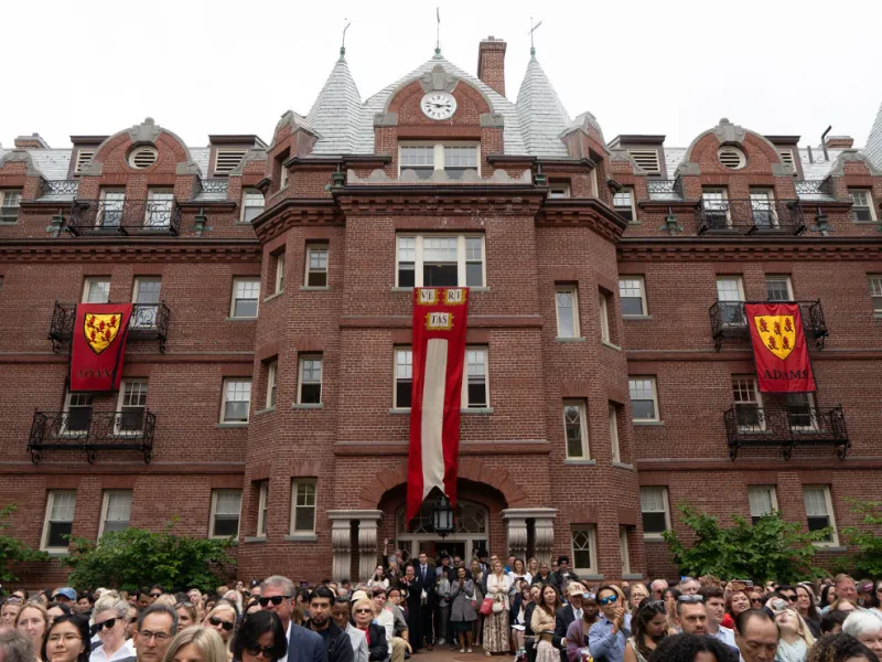 A colorful image of families gathered outside of Adams House on Commencement day 2026.