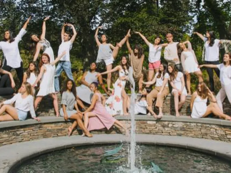 students dancing and posing on a bridge