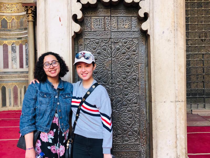 Two students in front of a mosque