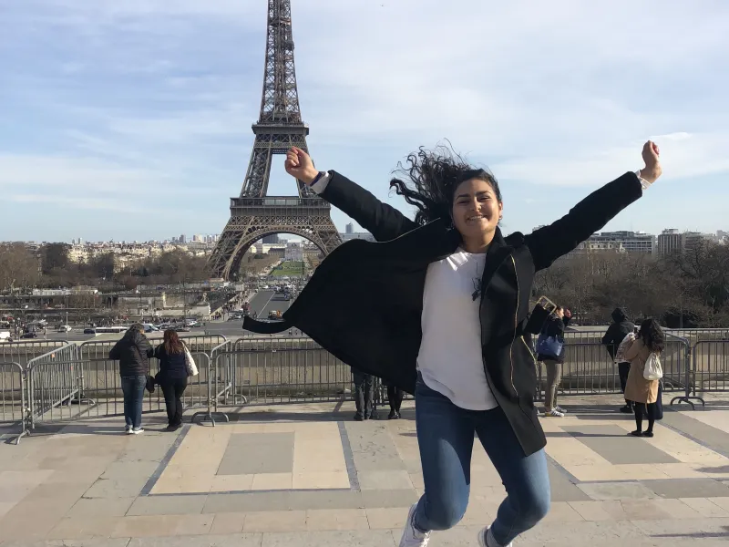 student jumping in front of the Eiffel Tower