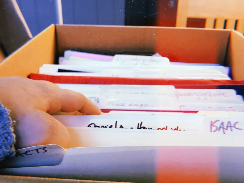Hand going through files in a box at an archive 