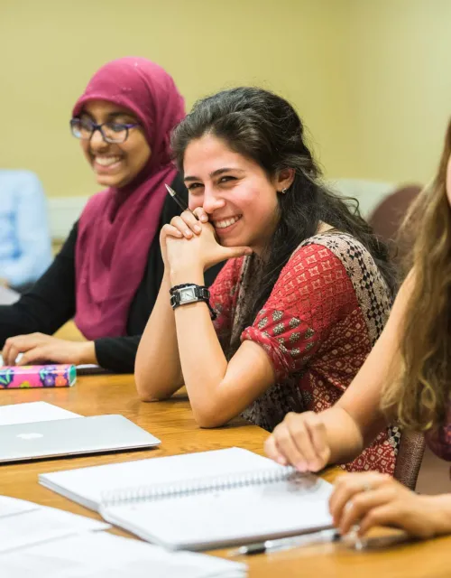 Three female students participating in a small class