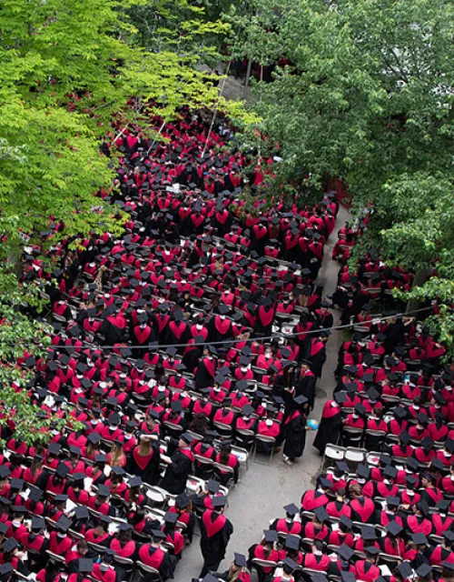 view from above of graduates sitting in Harvard Yard during commencement