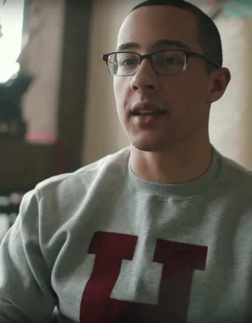 Student wearing Harvard sweatshirt talking