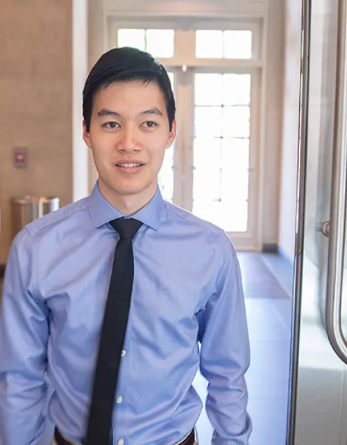 Michael Chen '20 standing in a doorway smiling at he camera.