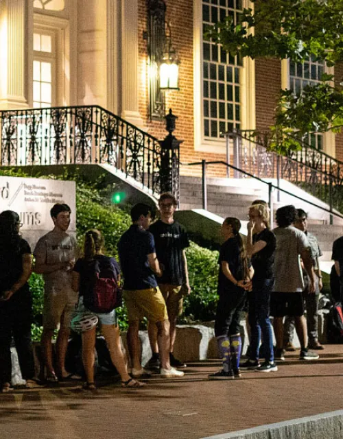 students standing outside at night waiting to get into the Art Museum