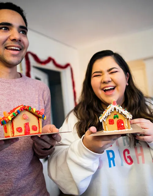 Lena Lofgren '23 and Kyle Felter '23 show off their completed gingerbread houses