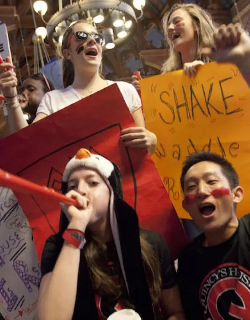 Students celebrating Harvard festivities in dining hall