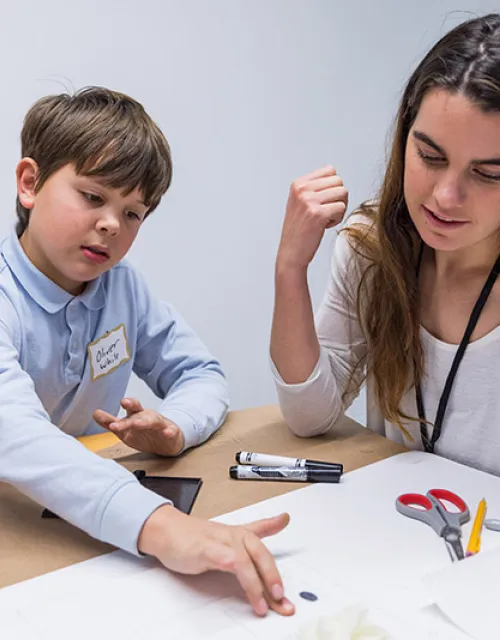 Grace Eysenbach '20, an electrical engineering concentrator, works with mentee Oliver White, 11, as they examine fingerprints on the cupcake box