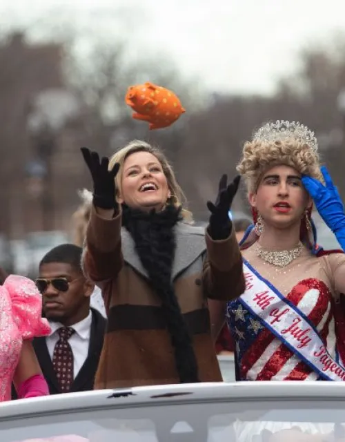 Hasty Pudding's Woman of the Year Elizabeth Banks catches a stuffed pig during the parade with Eli Russell '20 (left) and Scott Kall '20.