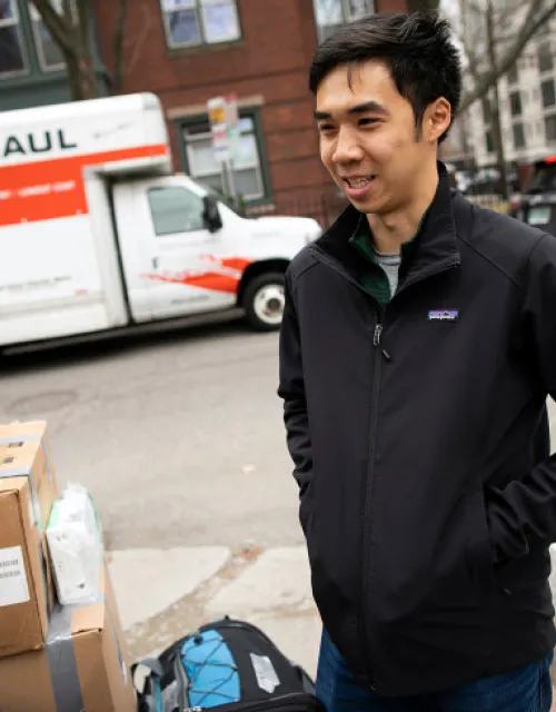 student standing outside with boxes and U Haul moving out of Quincy House